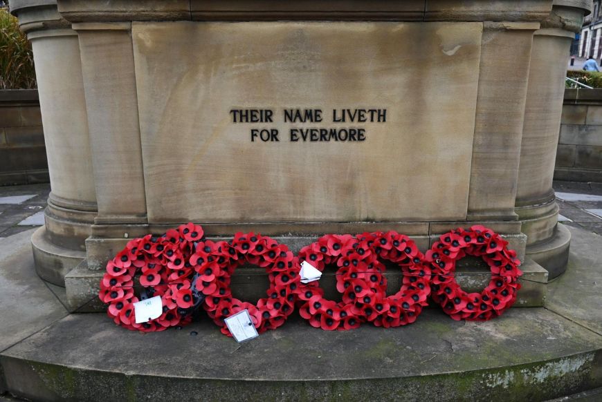 a memorial with red poppys around it, and carved into the stone "Their Name Liveth For Evermore"